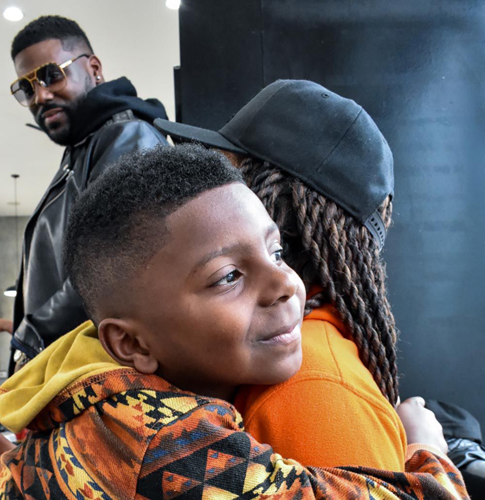 Young man hugging family member as father looks on. 'Kingdom Come', Jeremy Davis.